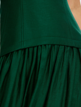 Floor-length deep emerald maxi dress with a structured silhouette, perfect for artistic and elegant occasions.