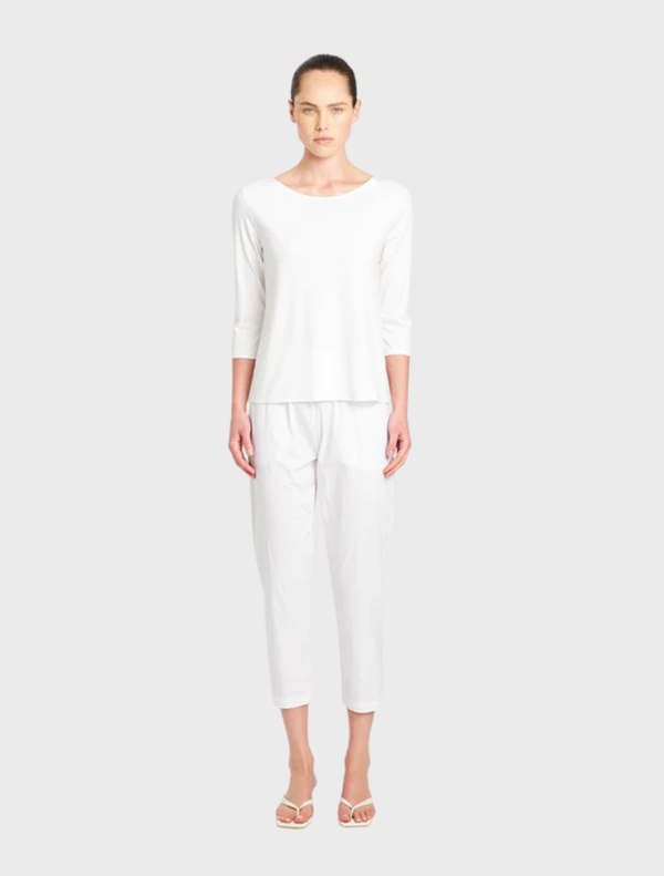 White relaxed boat neck top displayed on a hanger, showcasing its soft fabric and casual style.