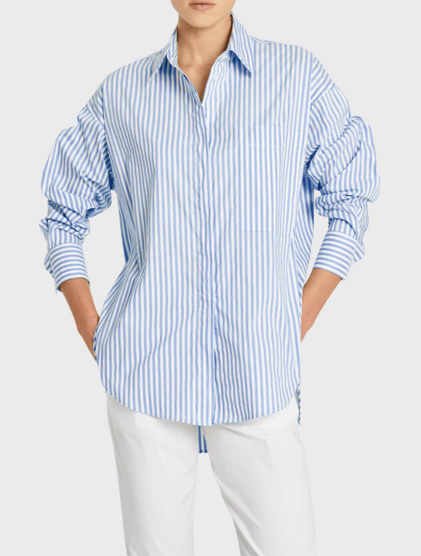 The image features a model dressed in a blue and white striped shirt, highlighting a trendy outfit choice.