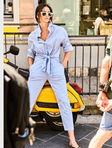A model is seen wearing a blue and white striped shirt, reflecting a modern and casual fashion sense.