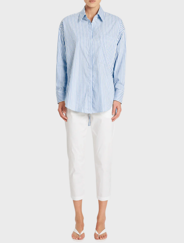  A model is wearing a blue and white striped shirt, showcasing a casual and stylish look.