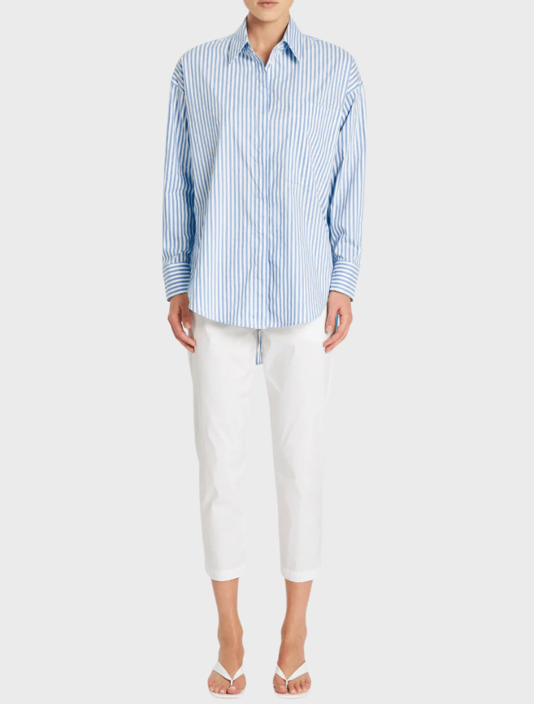  A model is wearing a blue and white striped shirt, showcasing a casual and stylish look.