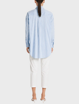 The image features a model dressed in a blue and white striped shirt, highlighting a trendy outfit choice.