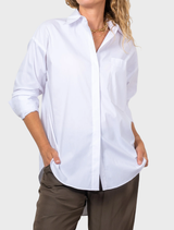White relaxed pocket shirt draped on a surface, emphasizing its casual elegance and versatility.