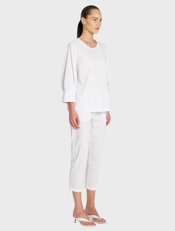 A white cotton top with puff sleeves, combining elegance and comfort in a versatile design.
