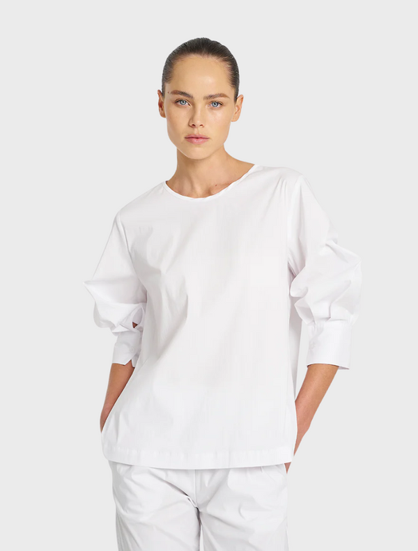 White cotton top featuring puff sleeves, offering a stylish and comfortable look for various occasions.