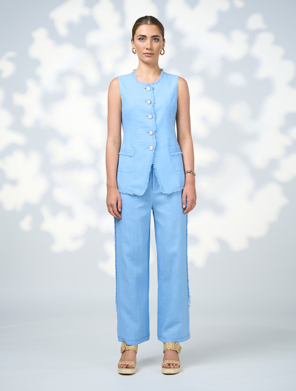 A model showcases a blue linen suit paired with sandals, named Romee Vest - Sky.