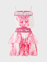  A vibrant pink-and-white mini dress with a shirred waist, adjustable straps, and a flared skirt featuring tile-inspired patterns.