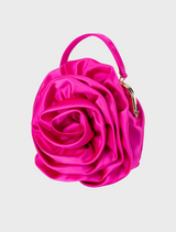 The Rosita Rosette Frame Bag in fuchsia, a pink satin flower bag, suspended from a stylish chain.