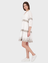 Stylish cream dress with a round neck, embellished with detailed embroidery for added charm.