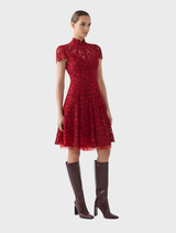 The Carmen A-Line dress in a vibrant ruby color features a tailored bodice and a graceful skirt, styled on a model.