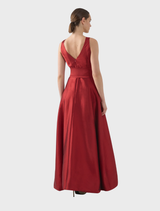 Chic ruby gown with a tailored fit and a dramatic skirt, designed for sophisticated evening wear or formal gatherings.