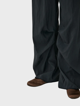 Black trousers exhibiting a rusty finish, combining modern design with a vintage aesthetic.