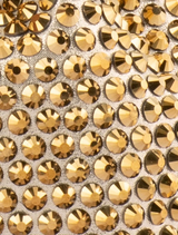 Chic gold pouch featuring a studded hotfix design, suitable for organizing small items with flair.