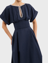 Full view of a navy sapphire gown, emphasizing its graceful draping and sophisticated style.