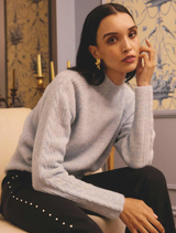 The Blue Frost Savanna Alpaca Blend Sweater draped elegantly, emphasizing its warm color and luxurious alpaca blend material.