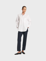 Saville shirt in white, showcasing a crisp design with a collar and buttons, hanging neatly on a hanger.