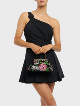 A stylish black and pink floral bag equipped with a metal handle, combining functionality with a fashionable design.