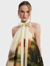 A serene pink mini dress with a halterneck style, elegantly draped on a hanger, highlighting its chic silhouette.
