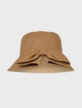 Tan straw bucket hat featuring a decorative bow on the front, labeled She's All Hat Hat.