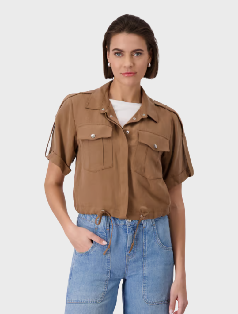 A model wearing a brown collar shirt and blue jeans, showcasing a casual outfit.