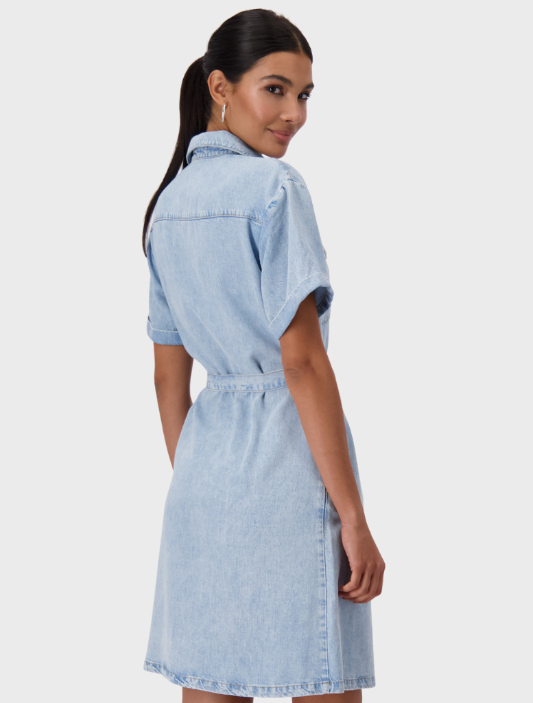 A woman in a denim shirt dress with a collar, made of lyocell, presenting a blend of comfort and style.