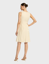Chic Nikita short dress in straw color, showcasing a modern silhouette for a fashionable look.