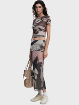 A woman dressed in a shirt with an eye-catching pattern, reflecting her personal style and fashion sense.