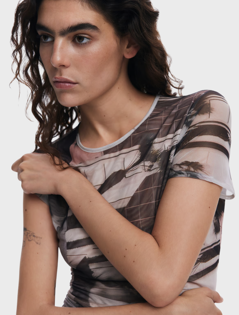 A woman wearing a patterned shirt, showcasing a vibrant design that adds visual interest to her outfit.