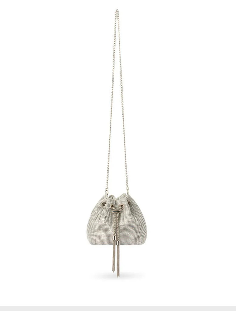 The Sylvie Crystal Pouch is a small silver leather bucket bag adorned with a tassel on its handle.
