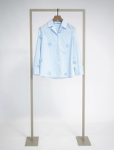 Feminine blouse featuring light blue and white stripes, floral details, notched lapel, and wide cuffs for versatile styling.
