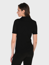 Close-up of a black knit top, emphasizing the stitching and material quality.