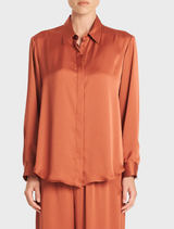 A soft copper-colored shirt displayed on a hanger, showcasing its smooth fabric and casual design.
