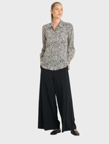A soft, fossil-colored shirt displayed on a hanger, showcasing its lightweight fabric and casual design.
