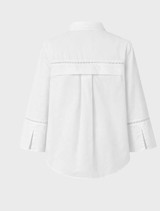 Oversized white shirt with broderie anglaise, featuring long wide sleeves with slits, a collar, and a front button closure.
