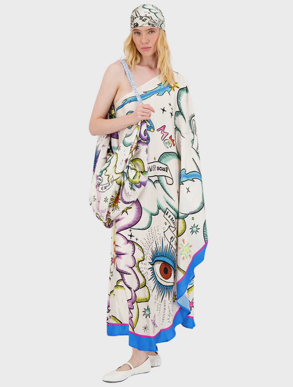 A woman wearing a white and blue scarf adorned with colorful graffiti patterns.