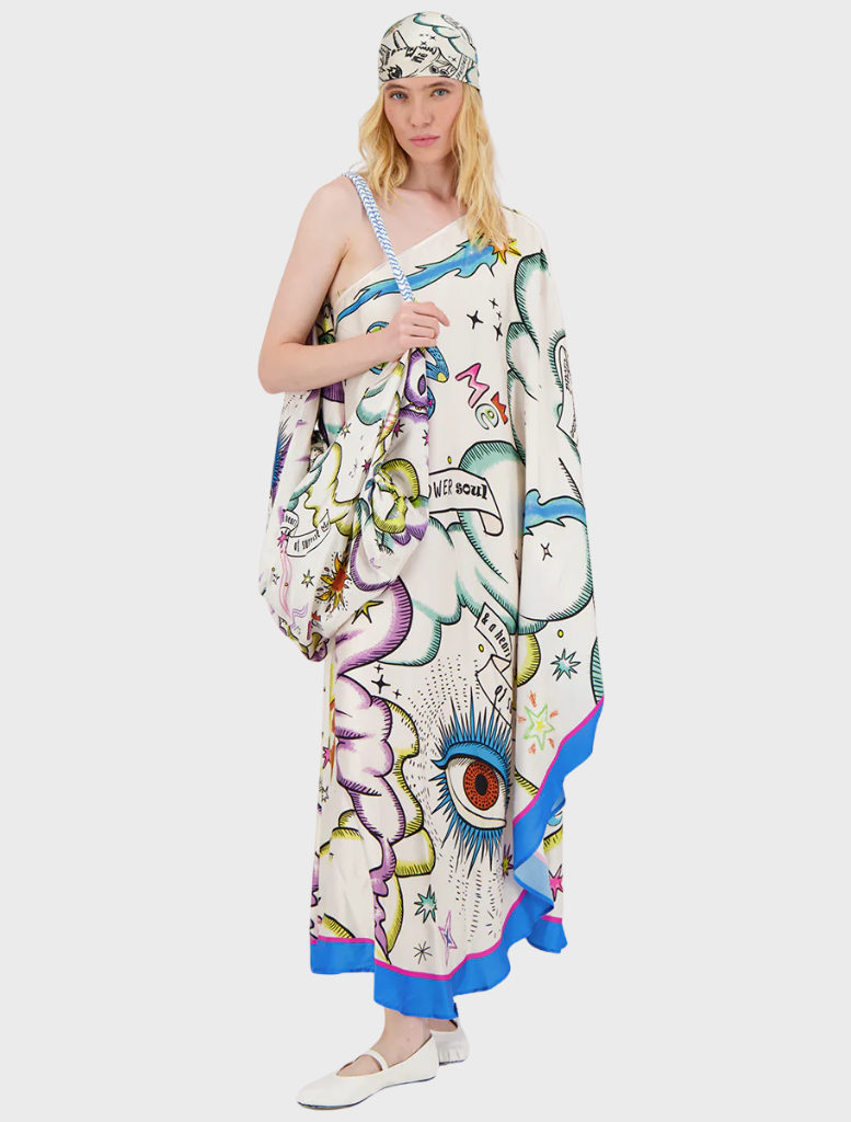 A woman wearing a white and blue scarf adorned with colorful graffiti patterns.