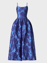 Elegant cobalt blue maxi gown featuring a sleeveless design, floral jacquard texture, and a flattering fit-and-flare silhouette.