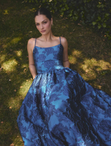 Elegant cobalt blue maxi gown featuring a sleeveless design, floral jacquard texture, and a flattering fit-and-flare silhouette.