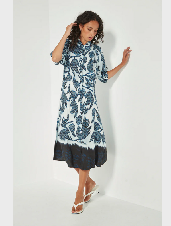 A model showcases a blue and white floral print dress, highlighting its vibrant colors and elegant design.