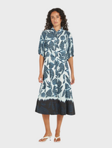 A model wears a stylish blue and white floral print dress, emphasizing the intricate floral design and color contrast.