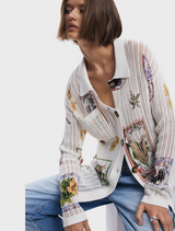 A model wears a white shirt embellished with a lively floral pattern.