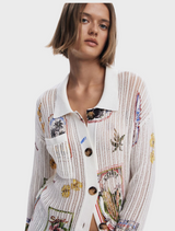 A model displays a white shirt decorated with a bright floral motif.