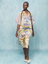 The dress features empowering purple and pink lettering with a dynamic sunburst, symbolizing joy and self-focus.