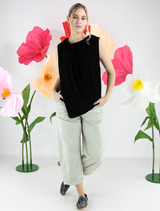 Black Stine top displayed on a hanger, showcasing its sleek design and fabric texture.