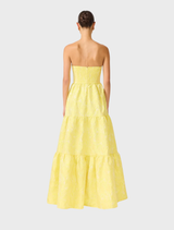 A yellow strapless gown displayed on a mannequin, showcasing its elegant design and flowing fabric.