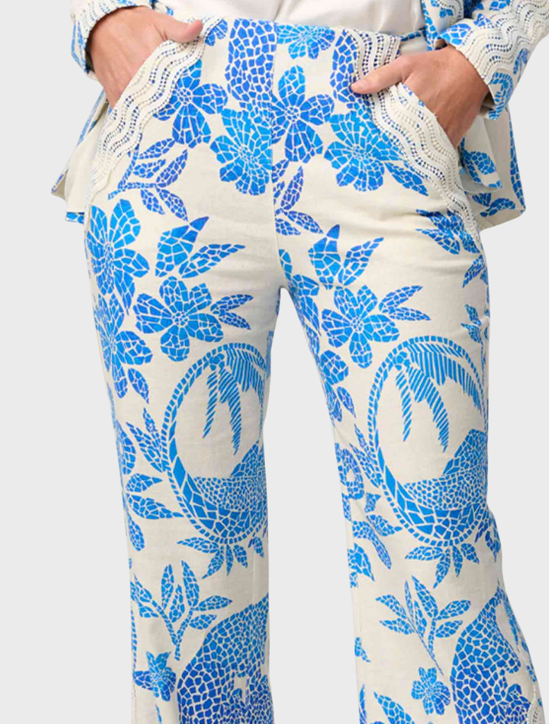 A woman models a blue and white floral suit, including the Leandro Contrast Lace Linen Viscose Stretch Pant in Azure Mosaic.