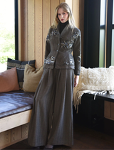 The Seam A Little Seam Jacket in gravel, featuring a contemporary cut, hangs against a neutral background.