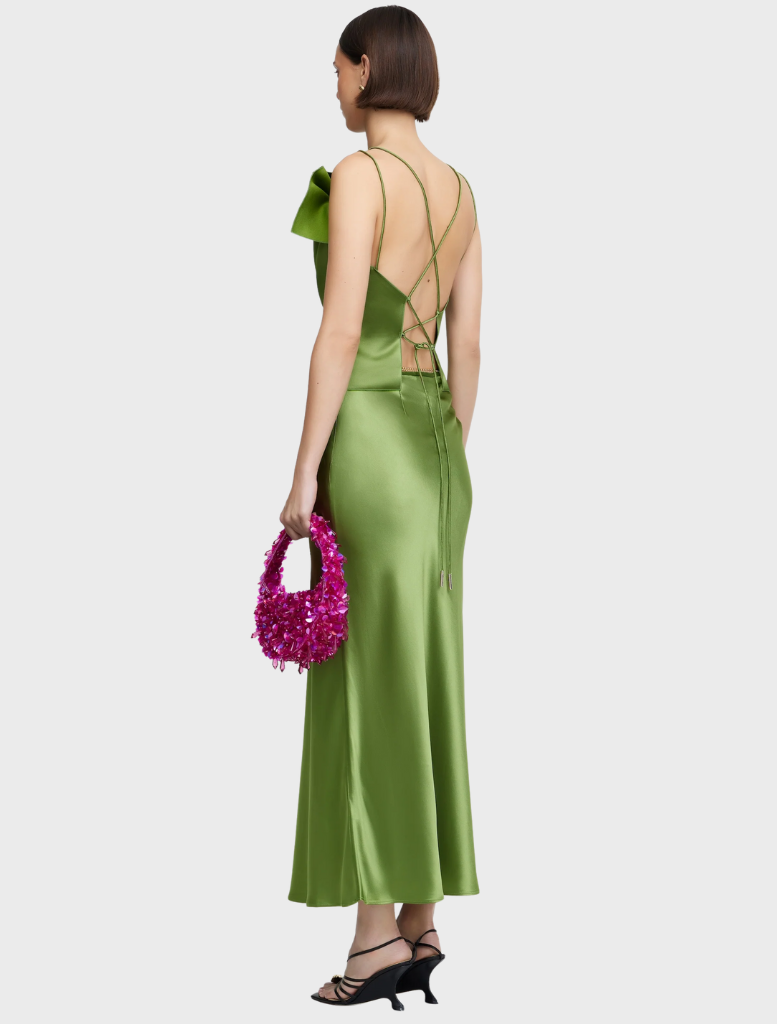 A green satin dress with a shoulder bow, presenting a refined and elegant look suitable for formal occasions.
