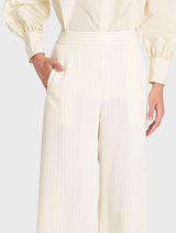 Vanilla and black suit pants draped on a surface, emphasizing their modern style suitable for formal occasions.